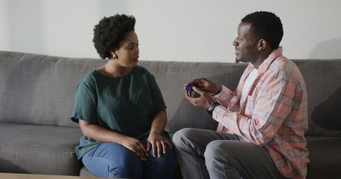 Romantic Proposal on Couch as Man Offers Engagement Ring to Partner