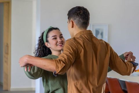 Young couple practicing dance in bright open-plan living space