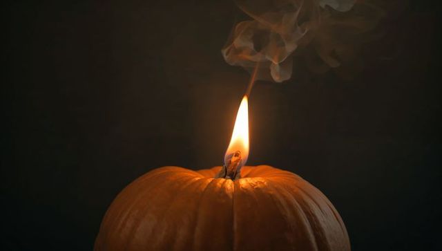 Glowing Pumpkin With Fiery Flame in Dark Studio Ambiance
