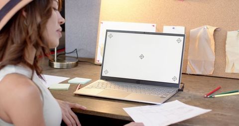 Creative Designer Reviewing Prints at Cozy Workspace