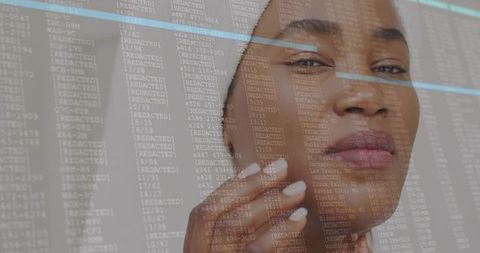 Midadult woman touching cheek in white turban with digital data overlay for skincare tech