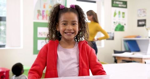 Cheerful Girl Smiling in Classroom Setting