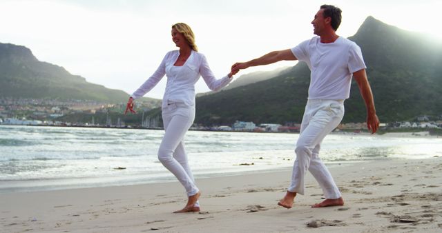 Happy Couple Walking Hand in Hand on Sandy Beach at Sunset - Download Free Stock Images Pikwizard.com