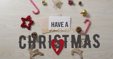 Merry christmas flatlay featuring greeting card, candy canes, ornaments and pinecones