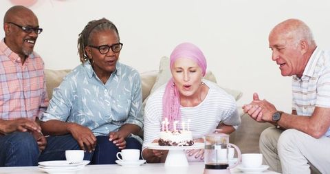 Senior friends celebrate birthday with cake and laughter