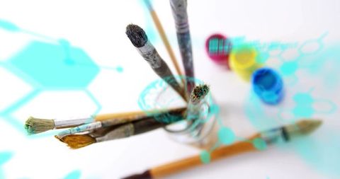 Paintbrushes in glass jar with turquoise digital overlay for creative studio design