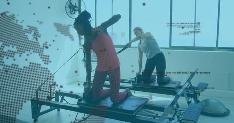 Women Practicing Pilates on Reformers in Modern Fitness Studio