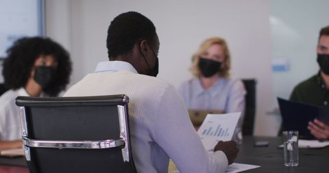 Diverse Team Meeting with Masks in Modern Office
