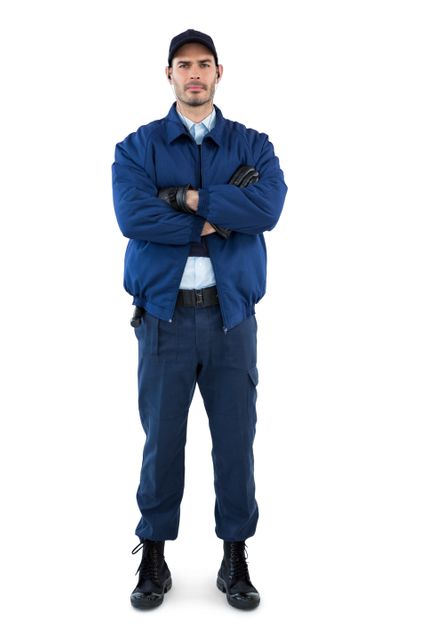 Portrait of security standing with arms crossed against white background