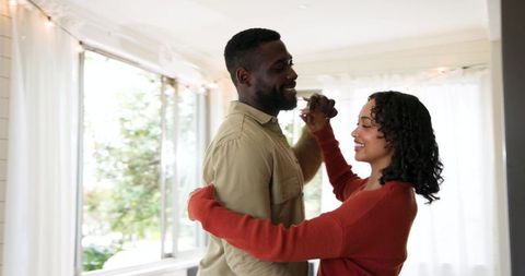 Joyful Couple Embracing Dance in Bright Living Room