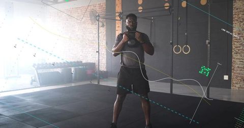 Male athlete performing kettlebell squat in industrial gym with motion-tracking overlay