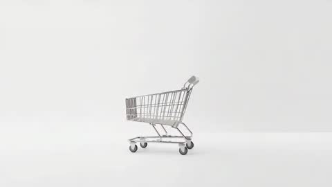 Minimalist High-Key Shopping Cart Rolling Across White Studio Loop Footage for Retail Ads