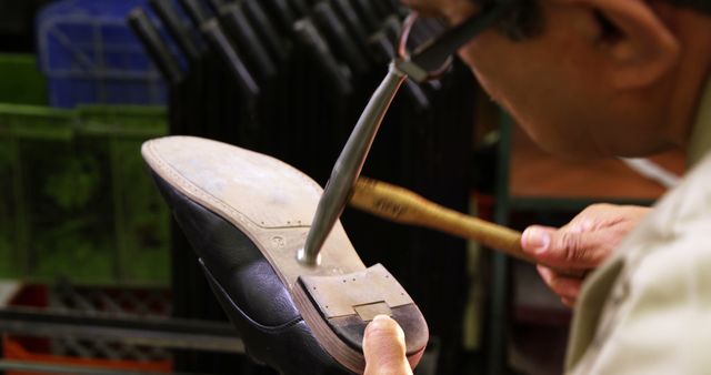 Cobbler hammering nail on a shoe in workshop 4k