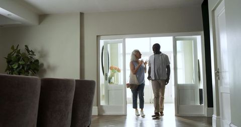 Senior Couple Walking Through Elegant Home Entrance