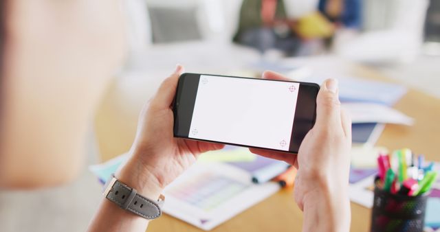 Hands Holding Smartphone in Office Setting with Blurred Background - Download Free Stock Images Pikwizard.com