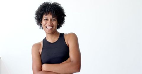 Joyful Biracial Woman in Sporty Outfit with Afro Curls Laughing