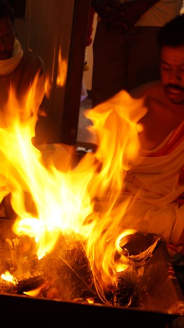 Traditional Hindu fire ritual with a priest burning incense and offerings. Ideal for use in articles, educational materials, and cultural documentaries showcasing Hindu customs and religious practices.