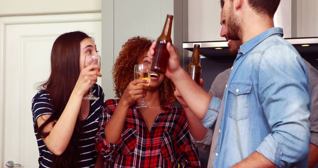 Friends celebrating together with drinks in modern kitchen - Download Free Stock Images Pikwizard.com