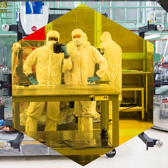Scientists in cleanroom suits, examining James Webb Space Telescope mirror at NASA Goddard Space Flight Center. Highlighting advanced space science and telescope technology. Ideal for educational materials, science articles, space science promotions, or futuristic technology showcases.