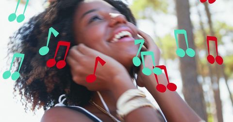Lively scene showing a young African American woman smiling while wearing earphones, surrounded by colorful music notes. Ideal for themes related to music, enjoyment, relaxation, and summer fun. Use this image for promoting music streaming services, dance events, or lifestyle blogs centered on youthful enthusiasm and love for music.