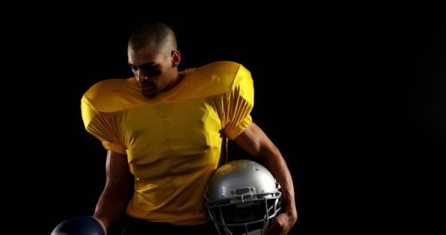 American Football Player Holding Helmet in Yellow Jersey - Download Free Stock Images Pikwizard.com