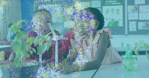 Elementary students studying plant growth and renewable energy using wind turbine model