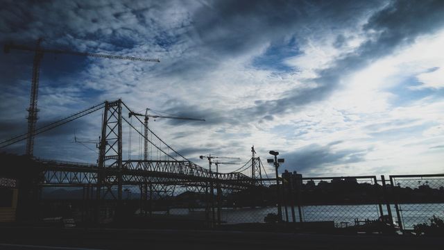 Dramatic Silhouette of Bridge Under a Cloudy Sky - Download Free Stock Photos Pikwizard.com