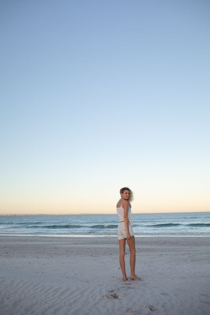 Beautiful woman standing on the beach  - Download Free Stock Photos Pikwizard.com
