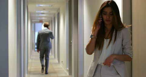 Businesswoman Talking on Phone in Office Corridor - Download Free Stock Images Pikwizard.com