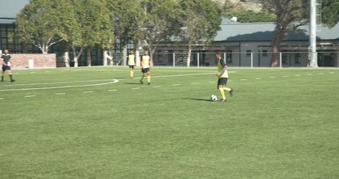 Youth soccer players in action near school building