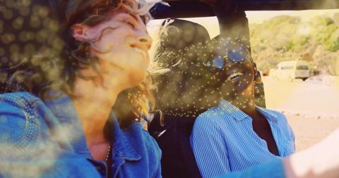 Carefree women enjoying road trip in open-top car