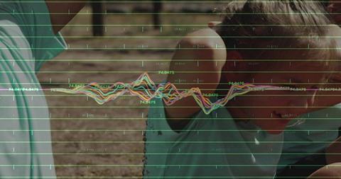 Boy leaning and shielding ear while colorful waveform overlay tracks audio in backyard