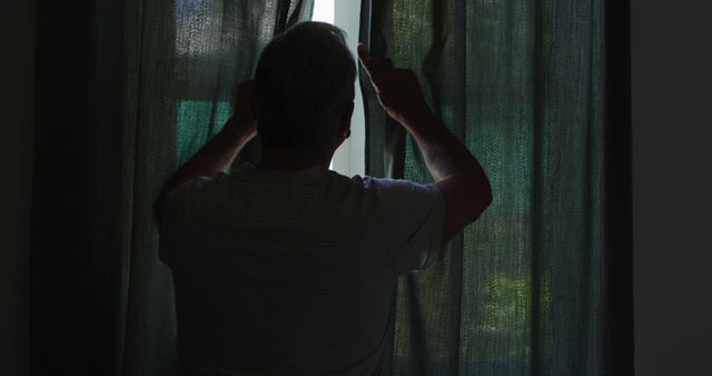 Silhouette of Man Pulling Dark Curtains Apart to Look Outside Window - Download Free Stock Images Pikwizard.com