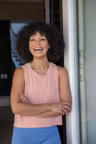 Joyful African American Woman Relaxing at Home in Sunglit Doorway