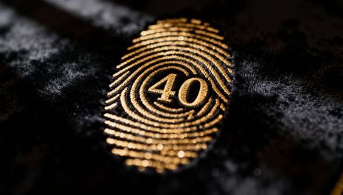 Gold fingerprint emblem numbered 40 embroidered on black velvet close-up