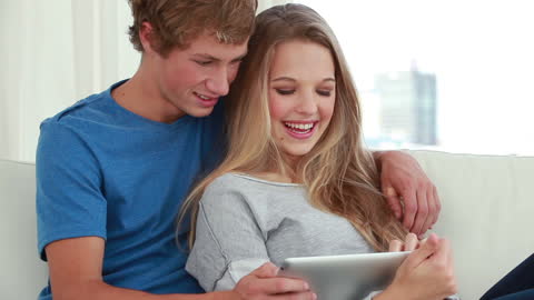 Joyful Couple Using Tablet Together at Home
