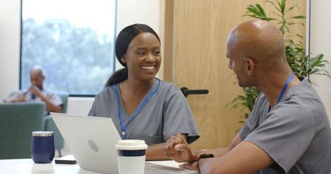 African medical staff collaborating in clinic break room with laptop and coffee