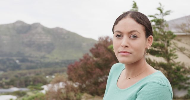 Confident Woman Outdoors in Scenic Mountain Setting with Green Sweater - Download Free Stock Images Pikwizard.com