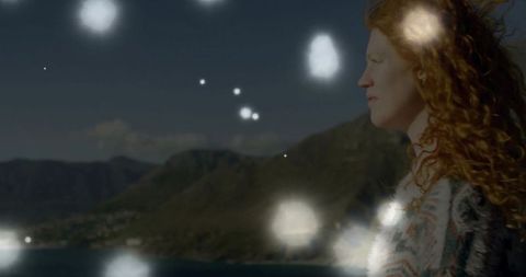 Gazing Woman Overlooking Mountain Bay with Sun Flares