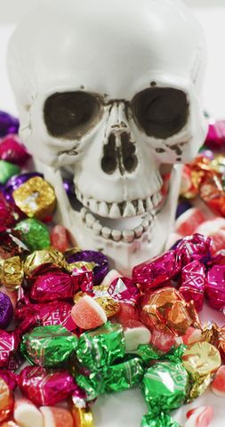 Halloween skull amidst colorful wrapped candy arrangement