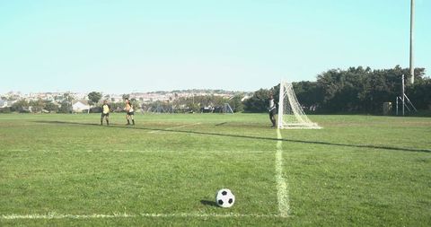 Soccer Referees with Goalkeeper on Grass Football Field