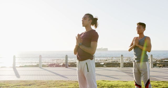 Two men meditating outdoors near the sea during sunrise - Download Free Stock Images Pikwizard.com