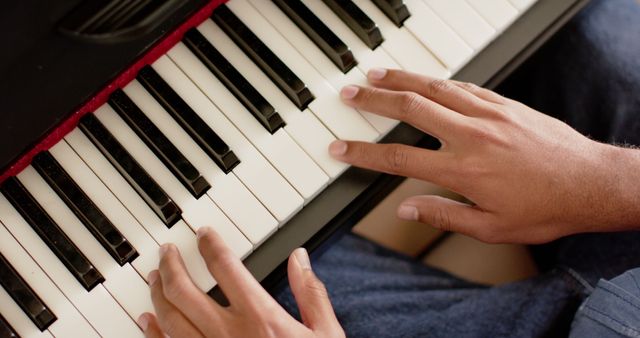 Close-up of hands playing piano keyboard, suitable for illustrating music practice, talent, and dedication. Ideal for educational materials, music journals, or hobby-related content.