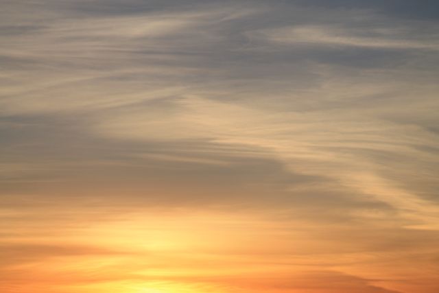 This image captures the beauty of a serene sunset with a sky filled with soft clouds. The gentle blend of colors creates a peaceful and tranquil atmosphere. Ideal for use in background settings, travel websites, relaxation and mindfulness promotions, or nature-themed artworks.