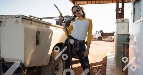 Confident woman refueling pickup truck at remote gas station