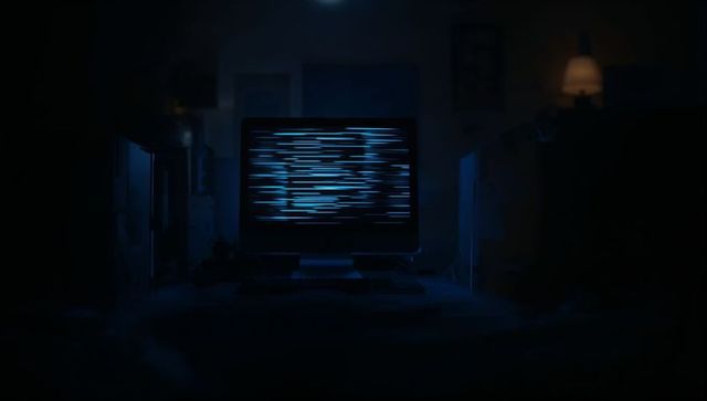 Computer monitor in dark room with digital blue bars