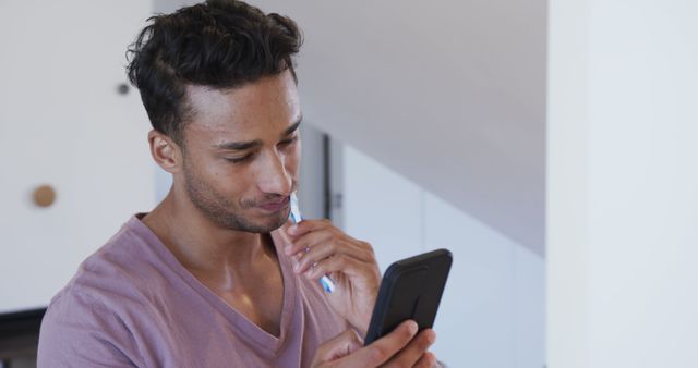 Young Man Concentrating While Reading Smartphone at Home - Download Free Stock Images Pikwizard.com