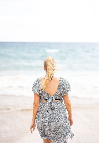 Woman in floral dress enjoying scenic beach view