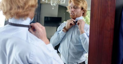 Groom and best man wearing suits and preparing for wedding