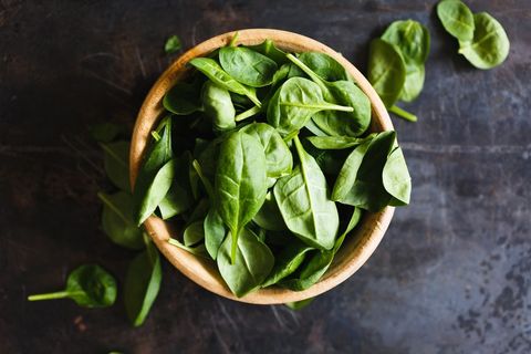 Fresh Baby Spinach Leaves in Wooden Bowl on Rustic Dark Surface
